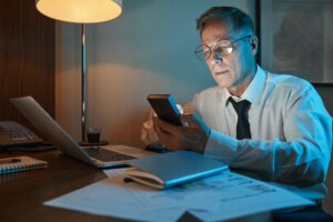Businessman working overtime in dimly lit hotel room